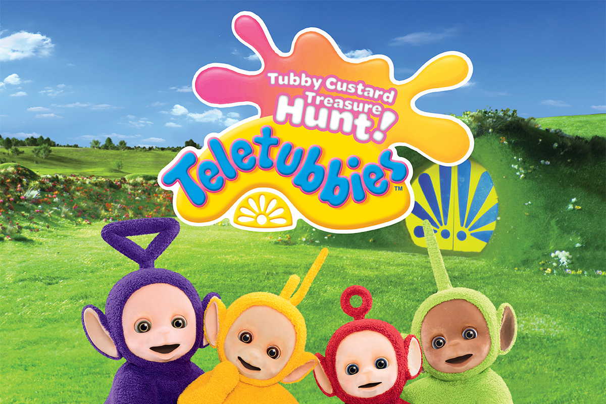 The four Teletubbies in a green field under a bright blue sky